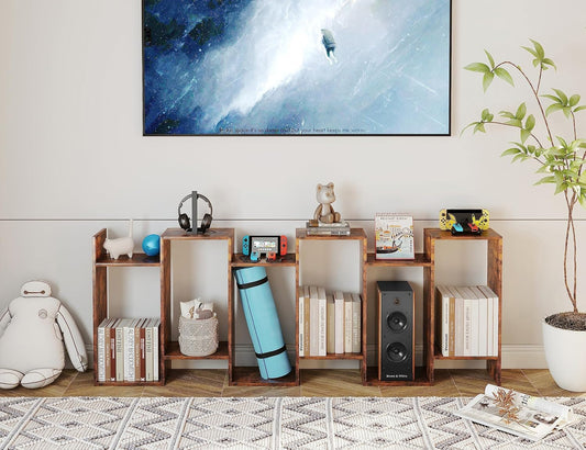 Wooden bookshelf with various items in a room with a large TV on the wall.