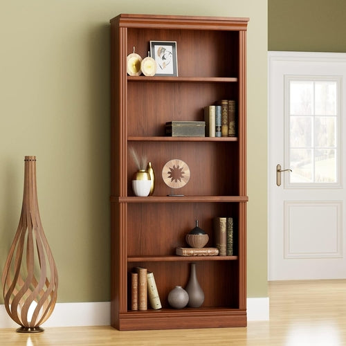 Wooden bookshelf with decorative items against a green wall