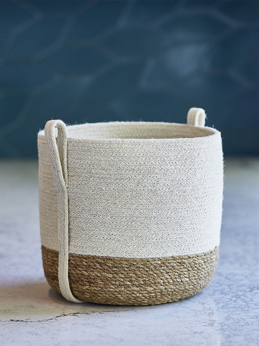 Woven basket with natural and white color scheme on a textured surface