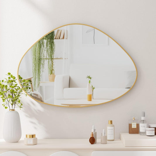 Round gold-framed mirror on a wall with decorative items below