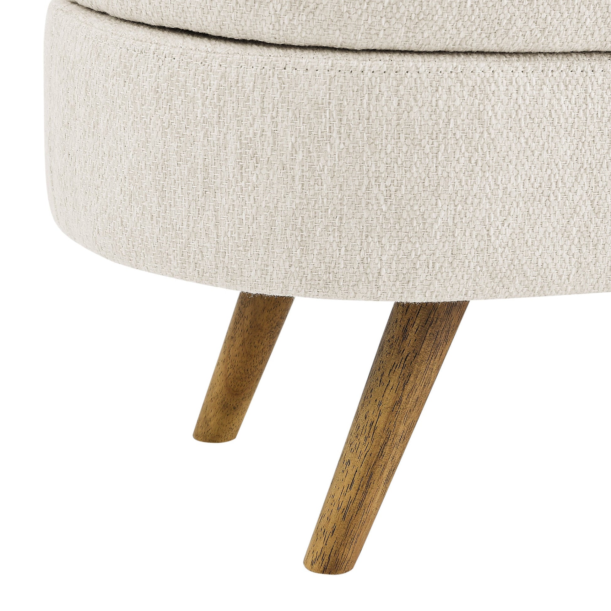 Round ottoman with beige fabric top and wooden legs on a white background
