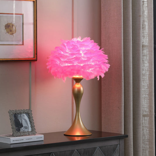 Pink feathered table lamp on a wooden surface with a blurred background