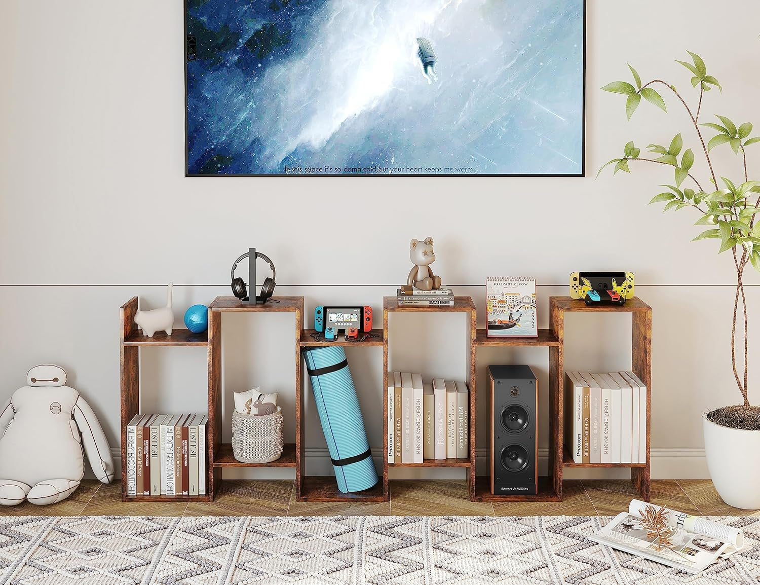 Wooden bookshelf with various items in a room with a large TV on the wall.
