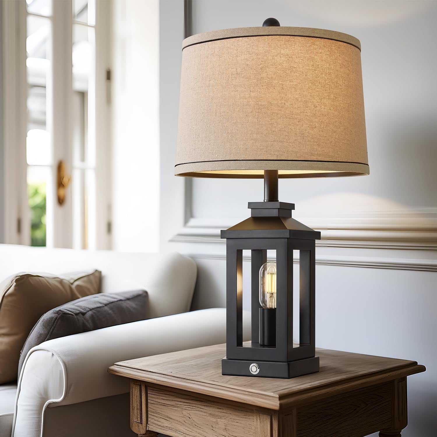 Table lamp with beige shade on a wooden table in a living room setting