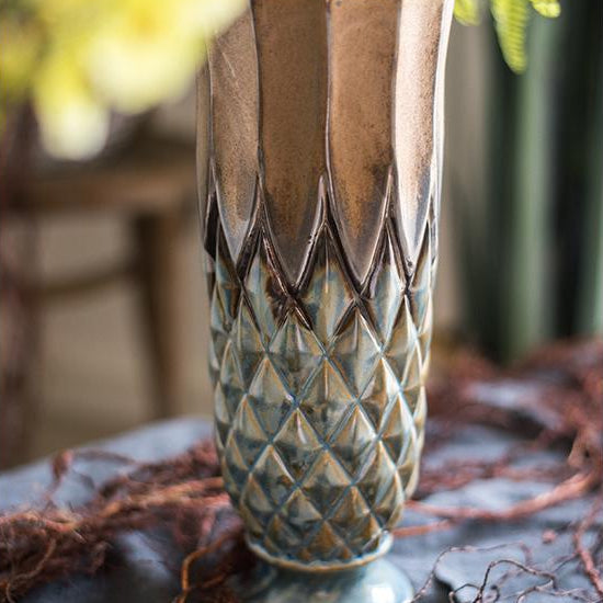 Decorative ceramic vase with a textured pattern on a dark surface with blurred background