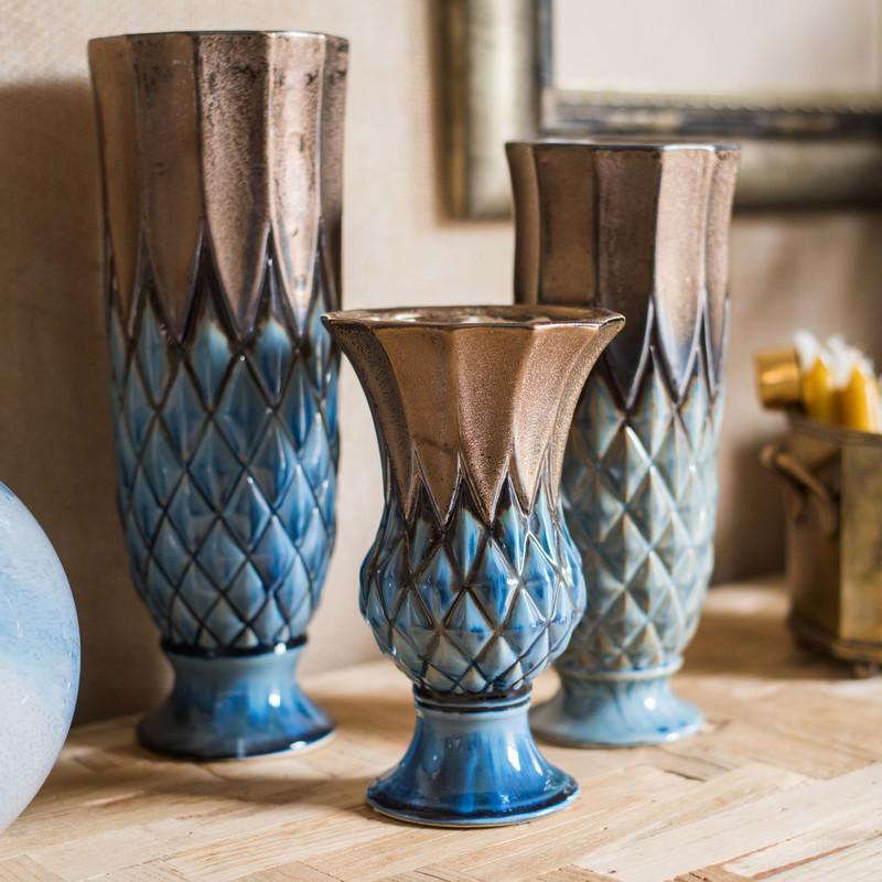 Set of decorative vases with blue and brown patterns on a wooden surface.